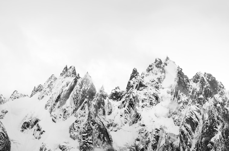 A black and white photo of snow covered mountains