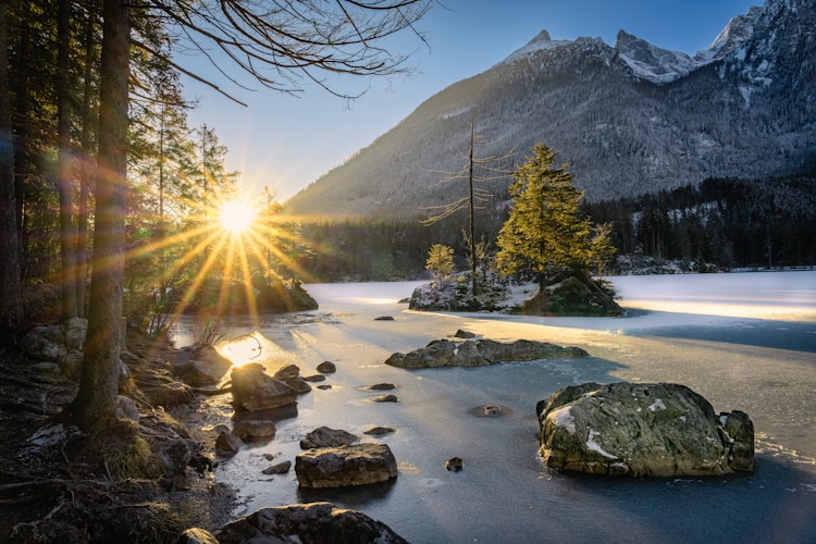 Sunrise illuminates a beautiful lake and snowy mountains.