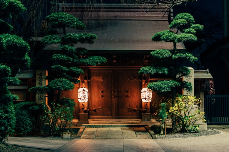 Japanese entrance at night with lanterns.