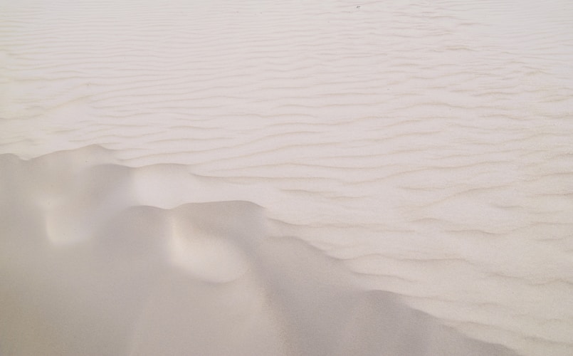 Sandy dunes create rippled patterns in the desert.