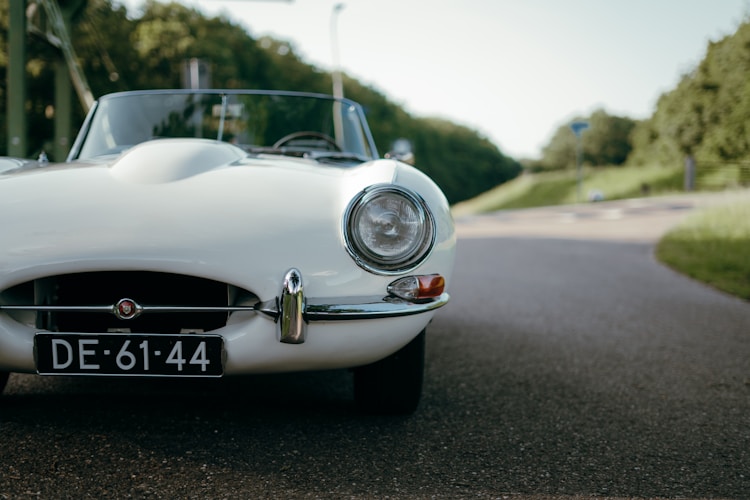 A classic white car parked on a road.