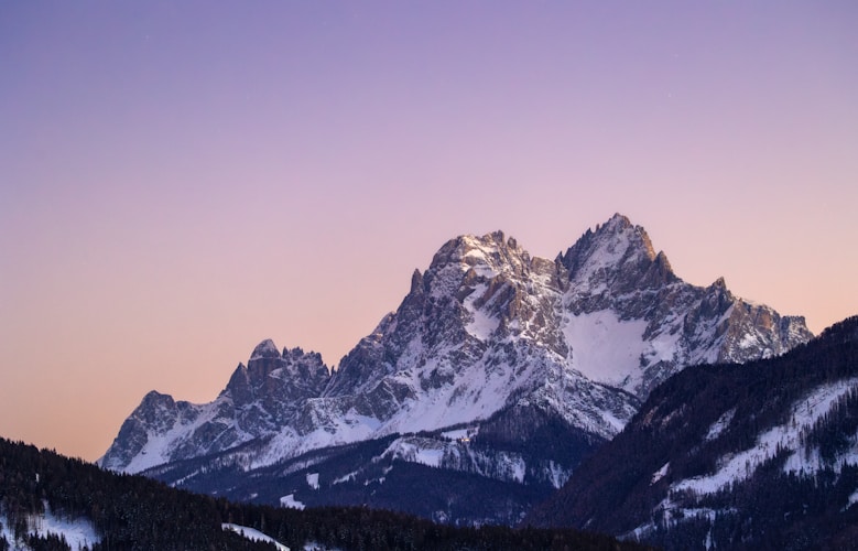 Snow-capped mountains against a colorful sky.