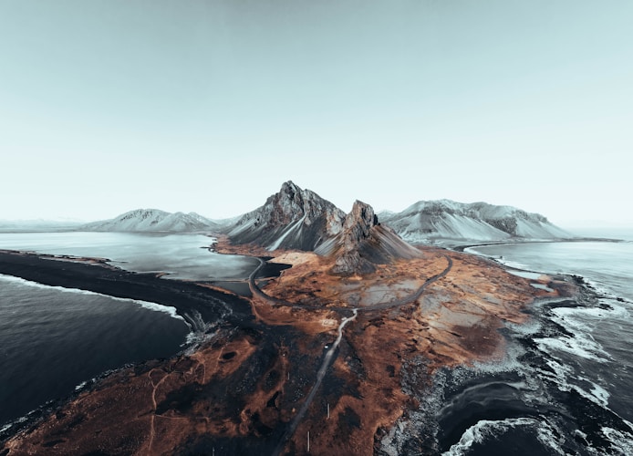 Mountains and water meet under a hazy sky.