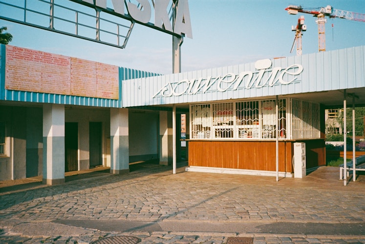 An abandoned souvenir shop underneath a sign.