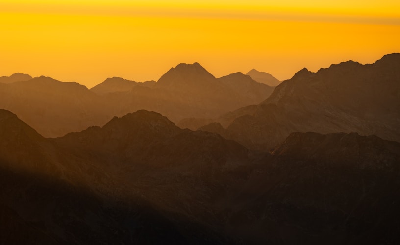 Mountains are silhouetted by a beautiful, golden sunset.
