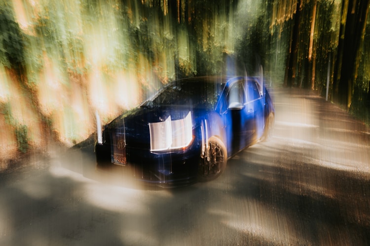 Blurred image of a speeding blue car.