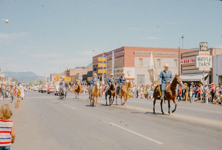 A group of people riding horses down a street