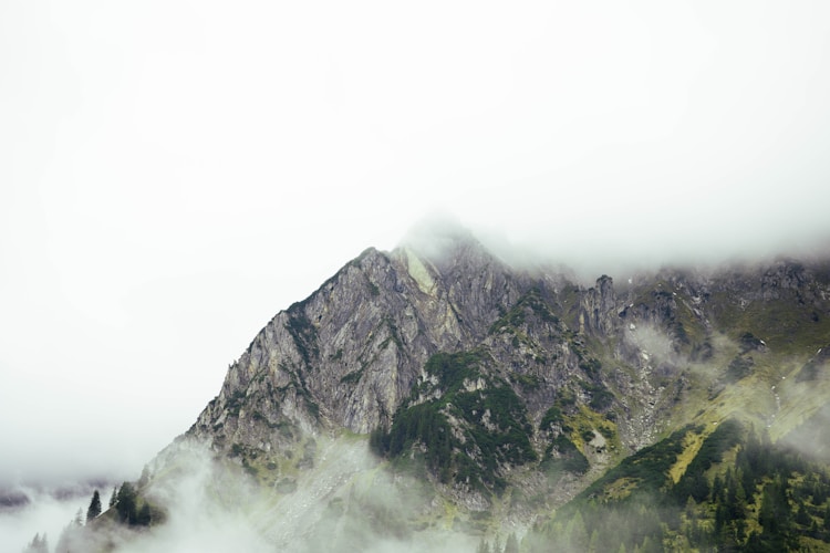 Foggy mountain peak amidst the clouds.