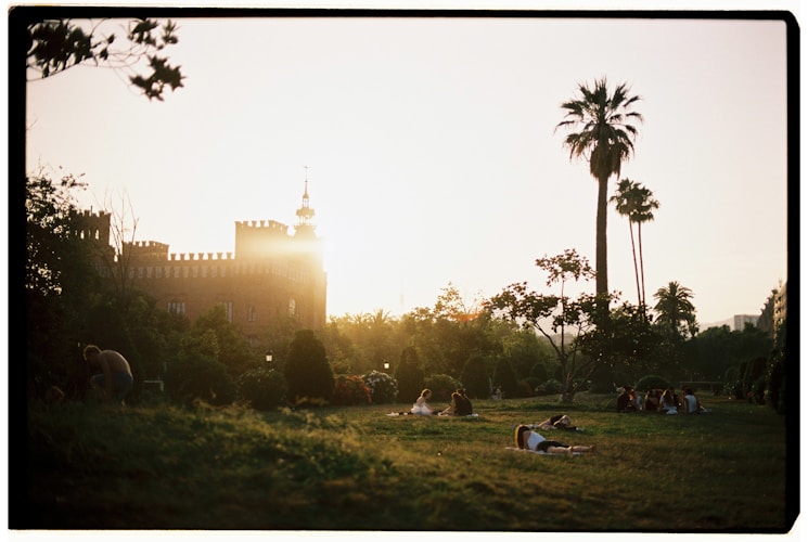 Sunset illuminates a park with a castle.