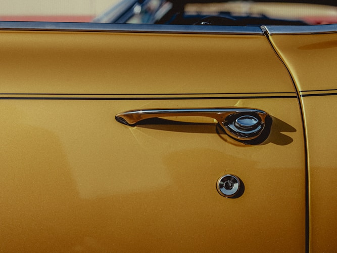 Door handle of a classic gold car.